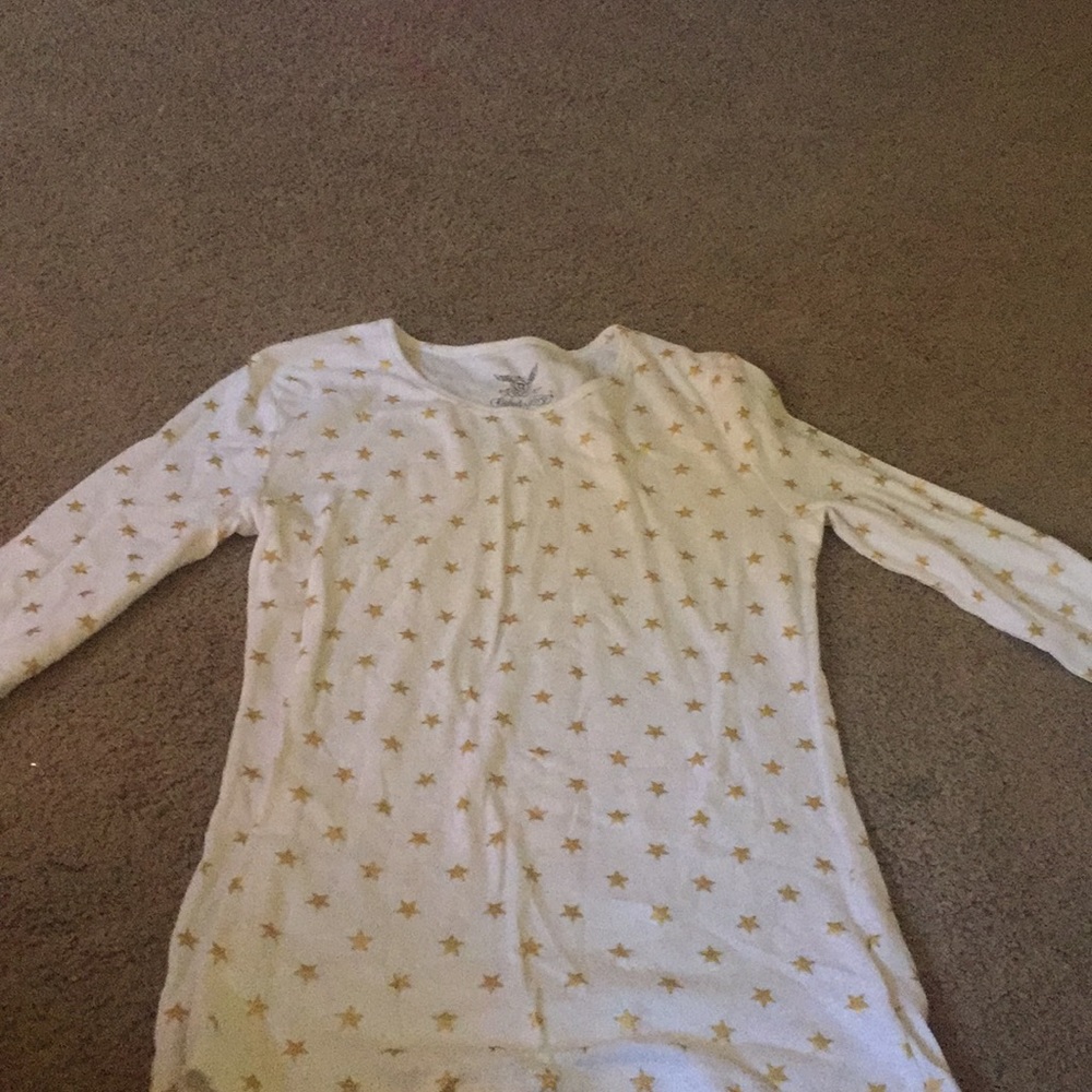 A white shirt that has gold stars on it